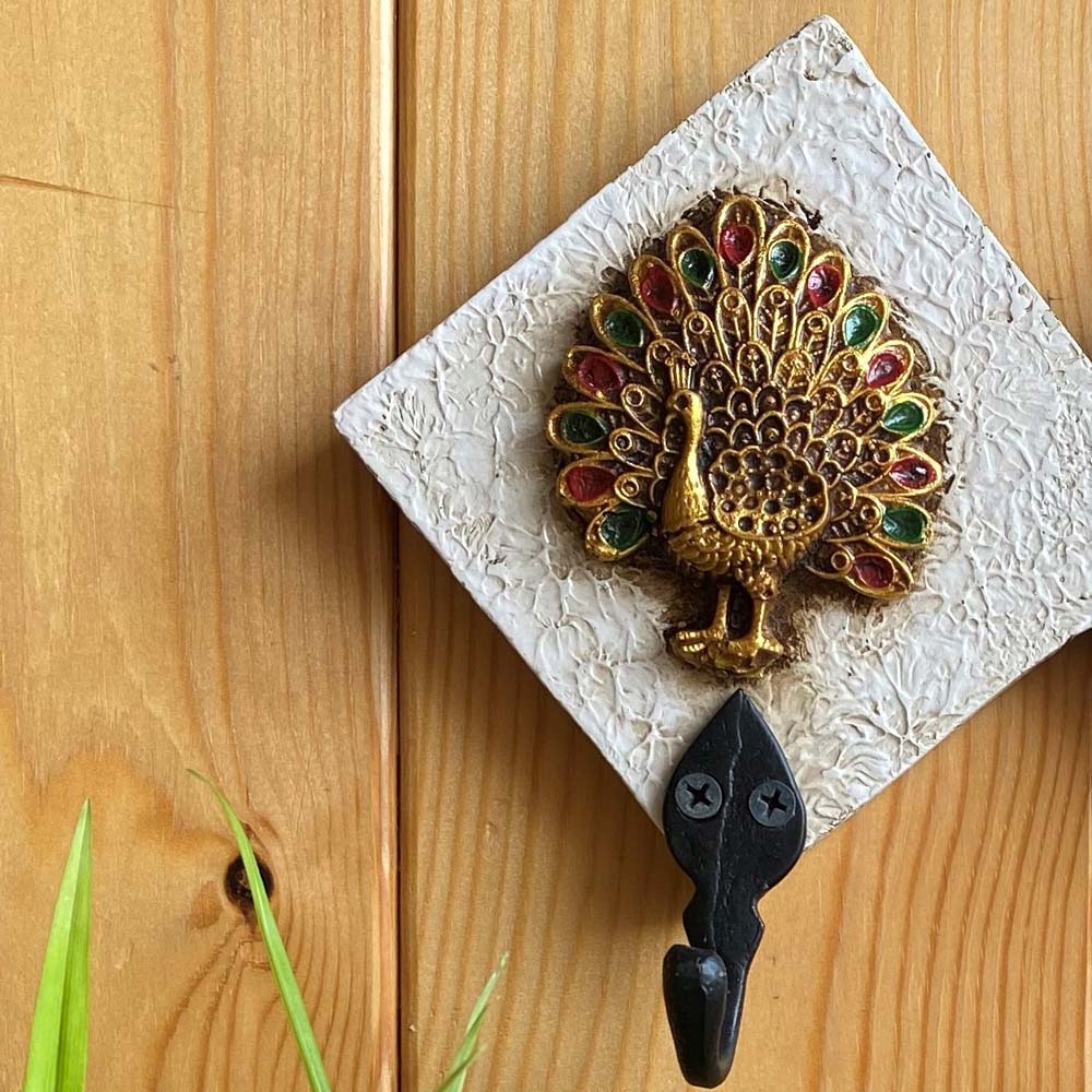 Handcrafted white key holder with a golden peacock motif featuring vibrant green and red accents.