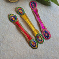 Pink decorative dupatta with peacock feather-inspired design, gold-tone embellishments, and colorful bead accents.