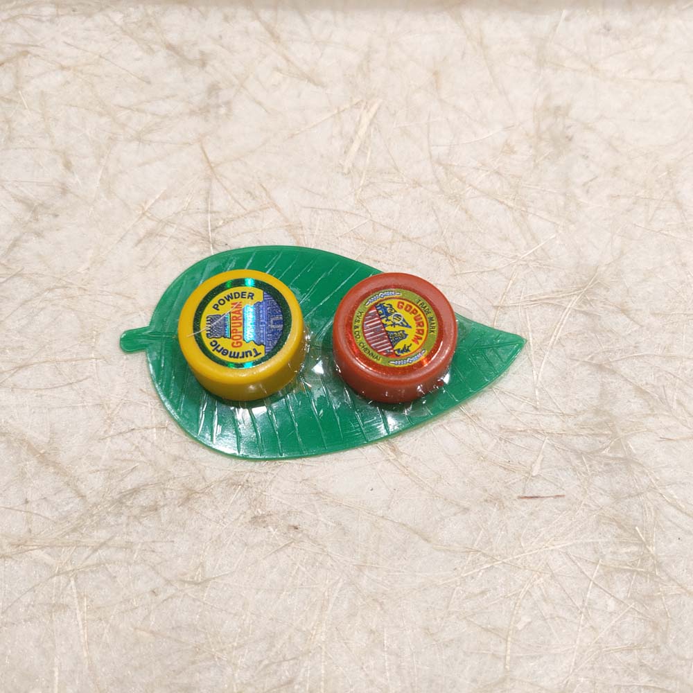 Gopuram Leaf Set with yellow turmeric and red kumkum containers on a green leaf-shaped holder, perfect for puja rituals and decor.