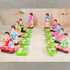 Handcrafted Navaratri Golu Sappadu Set featuring seated figurines enjoying a feast served on banana leaves, vibrantly painted and detailed.