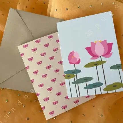 Two different lotus-themed greeting cards with a cream colored kraft envelope on bright yellow background.